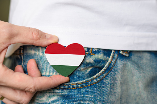 Patriot of Hungary! Wooden badge with the Hungarian flag in the shape of a heart in a man's hand.