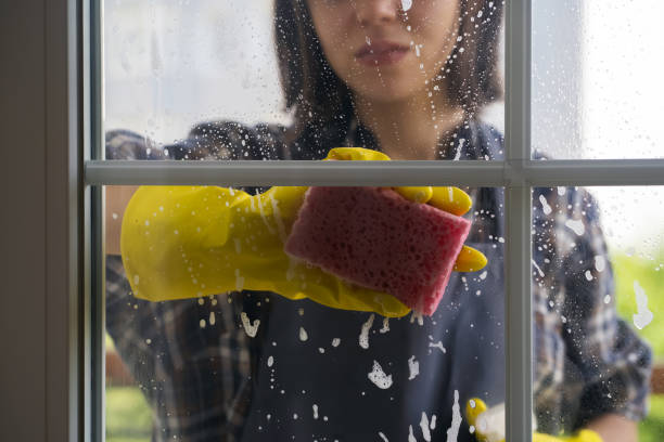 istock Woman washes the windows with a detergent. 1359565619