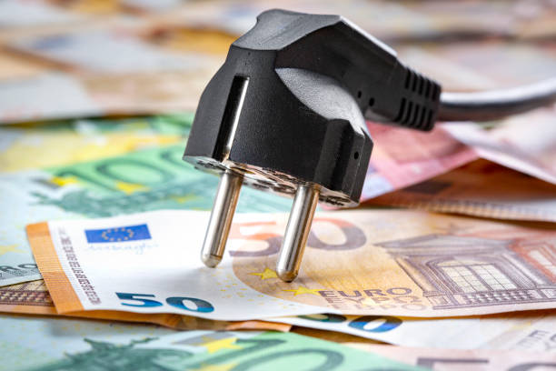 Black power plug and money - concept of cost of energy Black power plug and money - concept of cost of energy two pin plug stock pictures, royalty-free photos & images