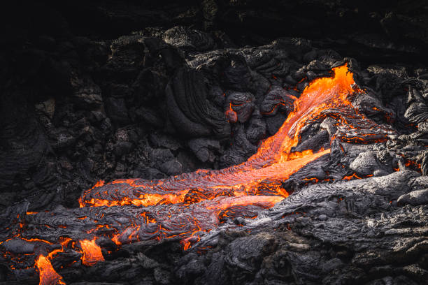 istock incandescent flowing volcanic lava in volcano 1359573763