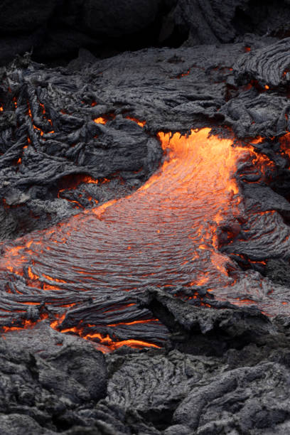 istock incandescent flowing volcanic lava in volcano 1359573766