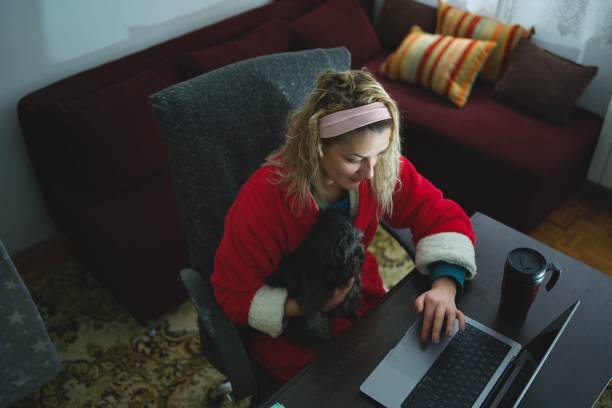 istock Young woman working at home office with her cute dog 1359575026