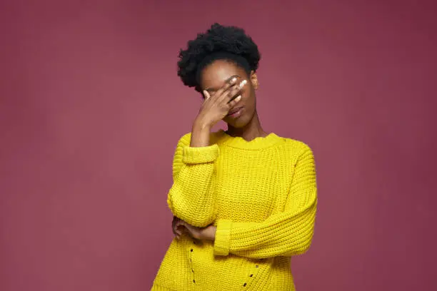 Facepalm gesture. Embarrassed african american girl with hand on face be shy, feeling sorrow regret blaming herself for failure. High quality photo