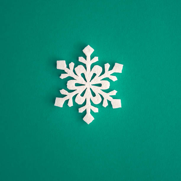 Christmas holidays composition, top view white snowflakes decoration on green and aquamarine background with copy space for text. Flat lay. Winter, postcard template stock photo