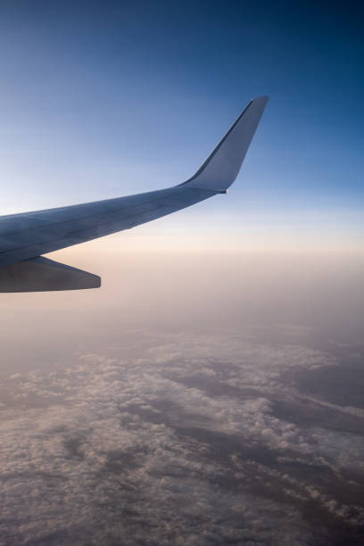 istock flying and traveling, view from airplane window on the wing on sunset time 1359583224