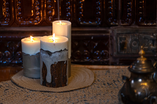 Three candles on the floor near the vintage fireplace