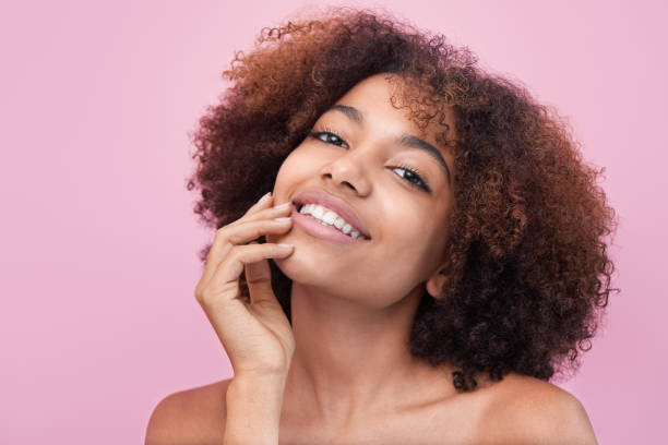 istock Brunette-haired woman poses against bright pink wall 1359585933