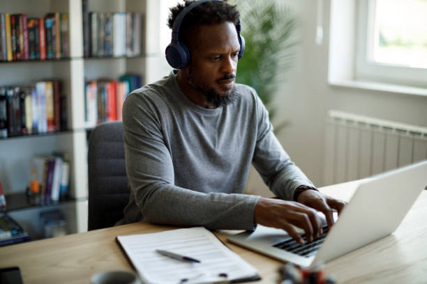 istock Man with bluetooth headphones working at home office 1359589432