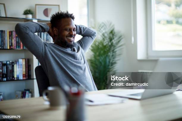 Happy Mid Adult Man Relaxing On A Chair At Home Office Stock Photo - Download Image Now