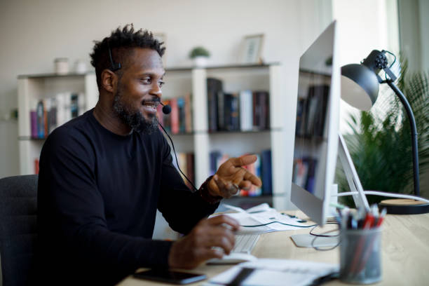 istock Smiling man with headset working from home 1359589595
