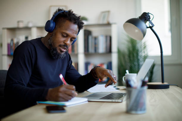 istock Man with bluetooth headphones working at home office 1359589657
