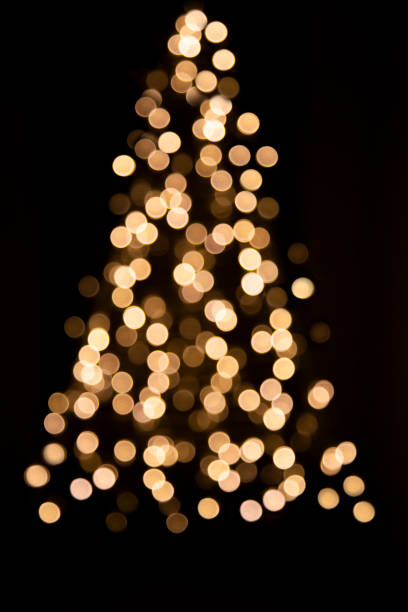 istock Unfocused Christmas lights on Christmas trees on a black background. 1359590576