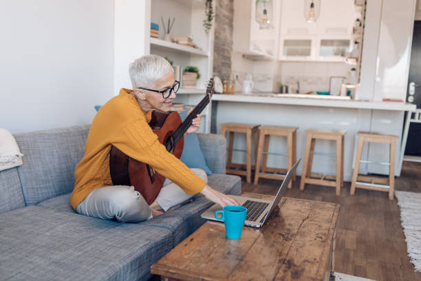 istock Senior woman learning to play guitar online 1359591886