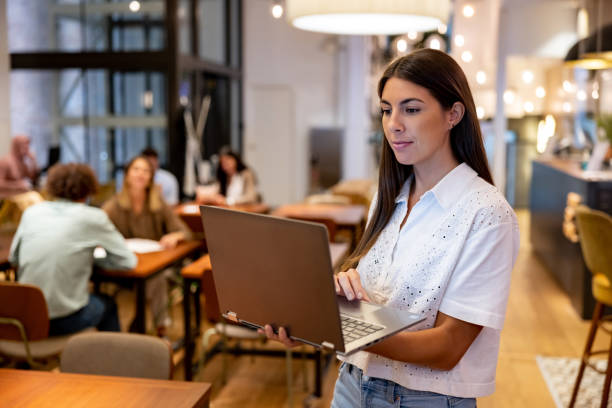 Business woman using a laptop while working at a coworking office stock photo