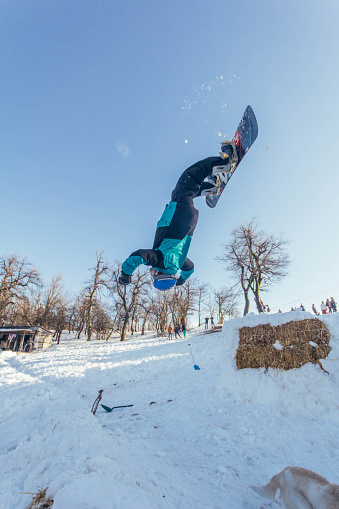 Snowboarder backflipping in local ski resort