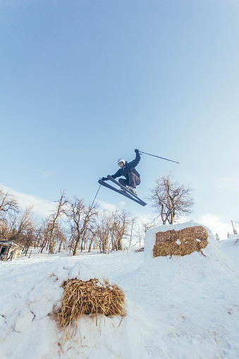 Single skier jumping high above at local ski resort