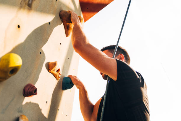 istock Muscular man practicing rock-climbing on a rock wall 1359595923