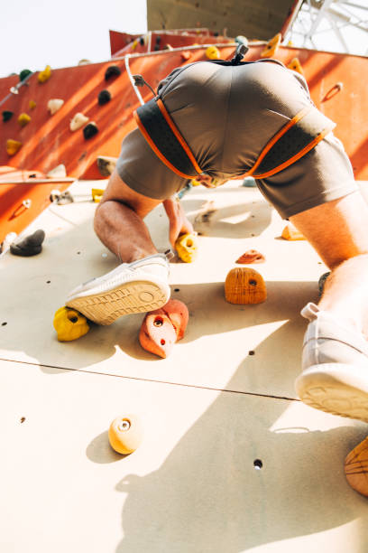 istock Young man exercising in climbing gym 1359595926