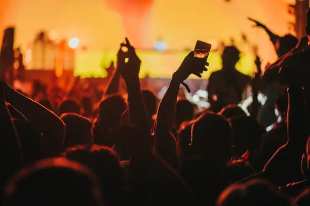 Photo of Man hand taking picture in a concert on a music festival