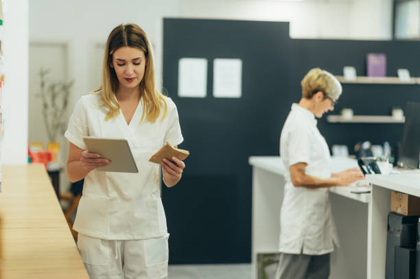 istock Two pharmacist working together in a pharmacy and using a digital tablet 1359597415