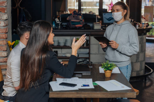 istock Successful young business people sharing ideas and smiling while working together on a project in a  coffee shop. 1359597881