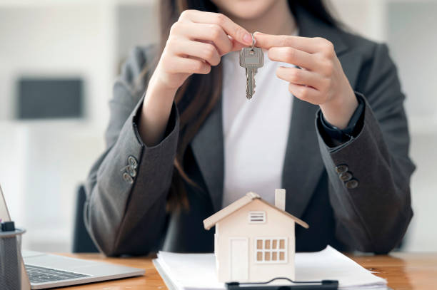 istock woman hand holding key, real estate concept. 1359612941