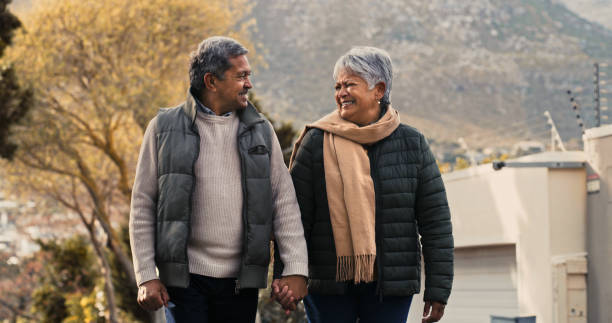 aufnahme eines glücklichen seniorenpaares, das einen romantischen spaziergang in der nachbarschaft macht - couple winter expressing positivity loving stock-fotos und bilder