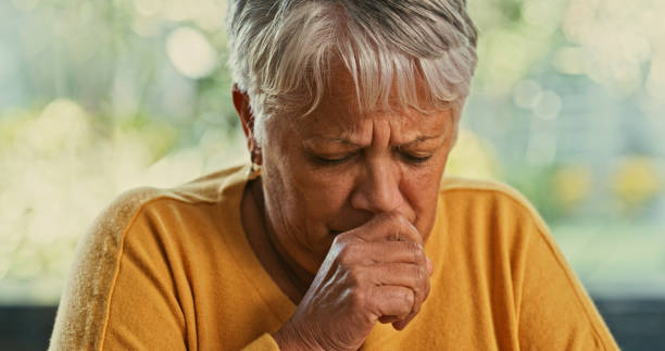 foto de una mujer mayor tosiendo en casa - coughing fotografías e imágenes de stock