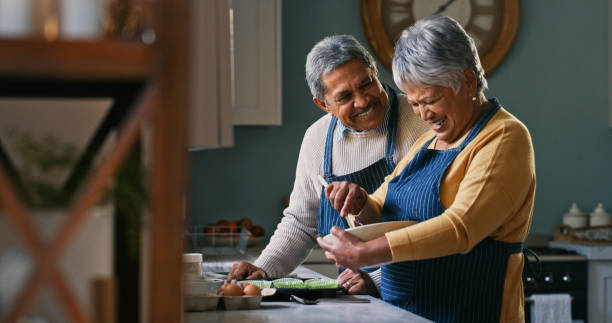 photo d’un couple de personnes âgées heureux cuisinant à la maison - home baking photos et images de collection