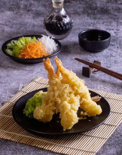 креветки темпура в черной тарелке с овощами и соусом для макания - tempura стоковые фото и изображения