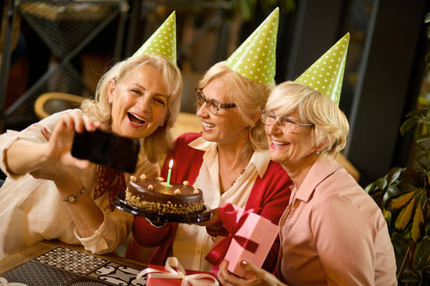 istock Senior ladies taking selfie while celebrating birthday in cafe 1359626668