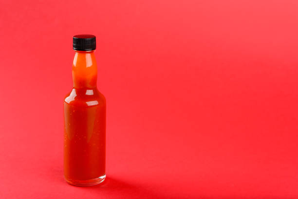 istock Hot sauce bottle on red background 1359627543