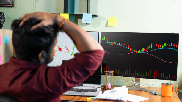 istock Focus on Monitor, Young man disappointed for failed strategy of trading while watching Graph on Computers at home office - concept of investing money on shares, analyzing stock market and financial 1359636392