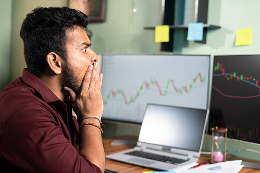 young intraday trader shocked due to sudden market crash while trading - concept of financial loss, risk in share or crypto markets.