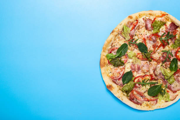 whole pizza fresh hot on a blue background. Top view, flat lay.