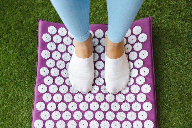 Women's feet standing on acupressure mat. Acupuncture massage Women's feet standing on acupressure mat. Acupuncture massage acupuncture mat stock pictures, royalty-free photos & images