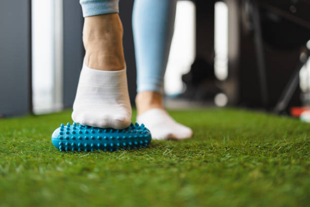 istock Woman massaging feet with a plastic roller 1359650127