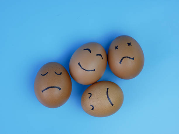 istock positive thinking concept, group of chicken eggs with sad faces and one smiling. 1359654746