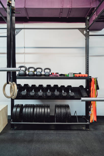istock Rows of metal dumbbells, kettlebells, weights plate for barbell on rack for strength training in gym. 1359654815