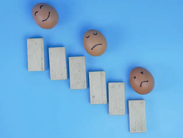 psychological mental investment concept, block chart with happy and sad face eggs.