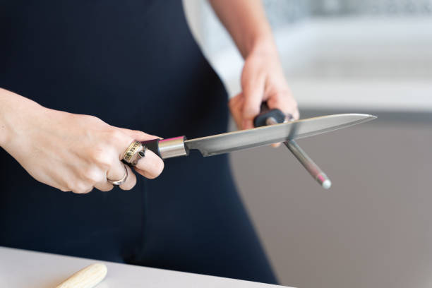 istock woman sharpening a knife with a grinder 1359656614