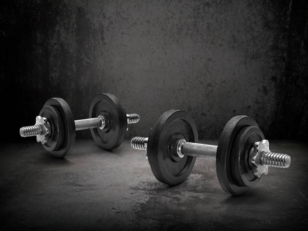 istock Dark gym interior with black dumbbells 1359658936