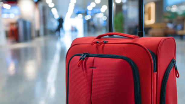 Red luggage in airport lounge stock photo