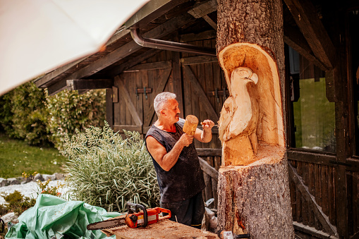 Man using hand tool for wood modelling