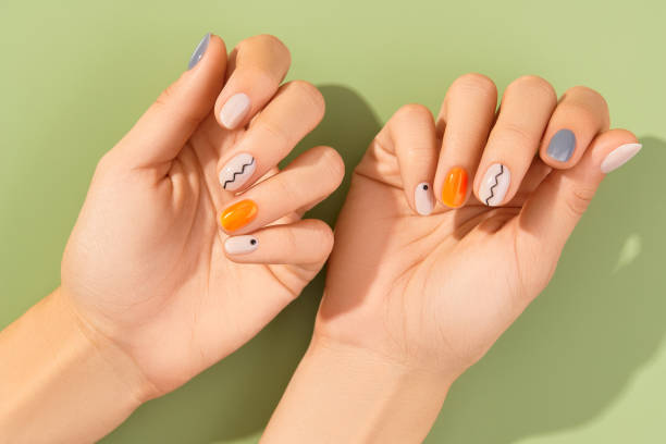 cierra las manos de las mujeres con manicura minimalista de moda sobre fondo verde. diseño de uñas primavera verano - nail fotografías e imágenes de stock