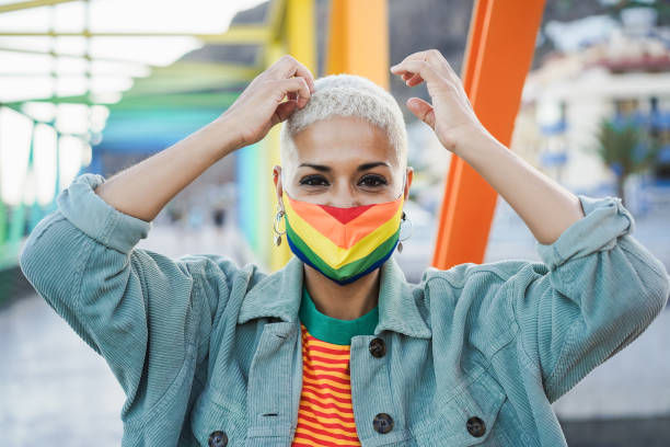 istock Young lesbian wearing LGBT rainbow flag pride mask - Focus on face 1359664949