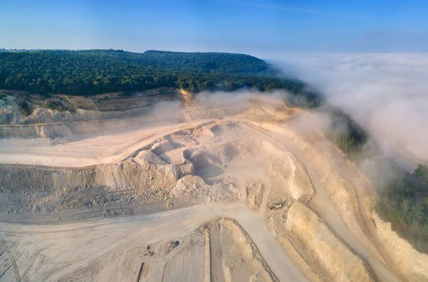 istock Aerial view of open pit mining site of limestone materials extraction for construction industry with excavators and dump trucks. 1359667403