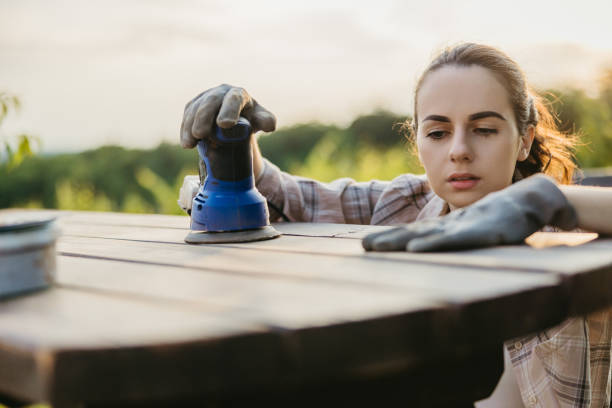 istock Young woman checking the table surface after sanding it with a machine 1359669150