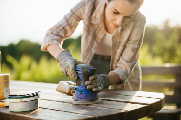 istock Woman with sanding machine sanding her garden table 1359669155