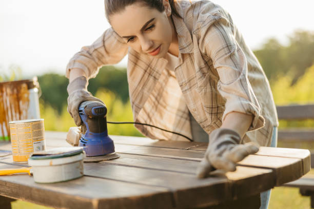 istock Young woman checking her wood table with her fingers after sanding it 1359669164